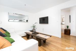 a white living room with a white couch and a table at Elephant Court - Comfortable, spacious house with parking in Reading