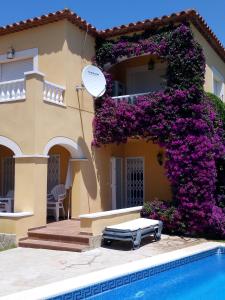 a house with purple flowers next to a swimming pool at Cassa Jessi in Tarragona