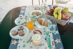 a table topped with plates of food and a basket of fruit at Poesia del Mare B&B in Syracuse