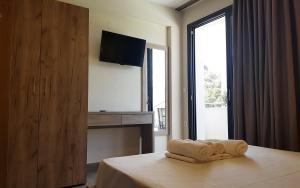 a hotel room with a bed with two towels on it at Sarti Holidays in Sarti