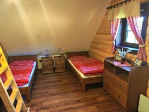 a room with two beds and a staircase at Bačova drevenica in Liptovský Ján