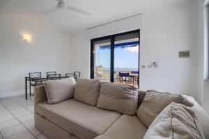 een bank in de woonkamer met uitzicht op de oceaan bij SUNSET GREG - fronte mare San Gregorio by LoveSud in Leuca