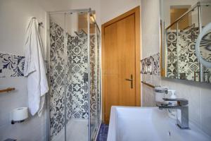 een badkamer met een douche en een witte wastafel bij SUNSET GREG - fronte mare San Gregorio by LoveSud in Leuca +20 foto's