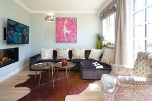 uma sala de estar com um sofá e duas cadeiras em NEU Ferienhaus Sylt Leev em Westerland