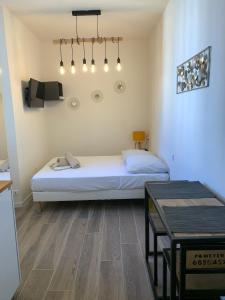 a bedroom with a bed and a table in it at Studio Vagliano in Cannes +3 photos