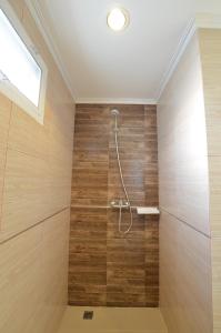 ein Bad mit einer Dusche und Holzwänden in der Unterkunft The Bliss Loei Living in Loei