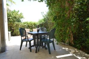 a table with chairs and a bottle of wine on it at Agriturismo Masseria sul Mare in Avola