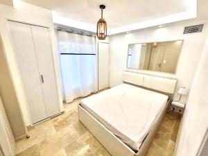 1 dormitorio con cama blanca y espejo en Mer & Calme en Saint-Mandrier-sur-Mer