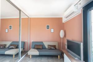 a living room with two couches and a flat screen tv at DNS Apartment in Kavála