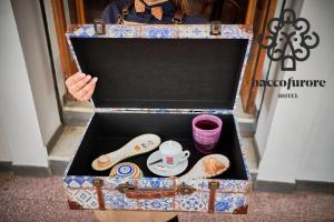 a woman is holding a box with food in it at Albergo Diffuso Bacco Furore in Furore