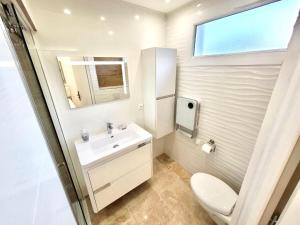 baño con aseo y lavabo y ventana en Mer & Calme en Saint-Mandrier-sur-Mer