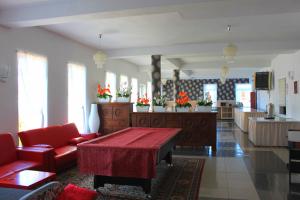 a living room with a red couch and a table at Villa Happy Rose in Dąbki