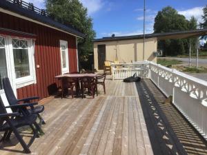 a wooden deck with a table and chairs on a house at Västerdala Onwest in Äppelbo