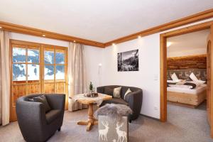 a living room with two chairs and a bed at Gästehaus Wineberger in Bad Hindelang