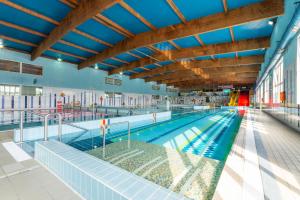 a large swimming pool in a building with blue ceilings at Hotel Jan in Darlowko