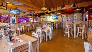 um restaurante com mesas e cadeiras de madeira e um bar em Roadcamp - American Motel & Sportsbar em Marl