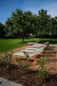a row of white lounges on a wooden deck at Motel Eldorado in Mikulov