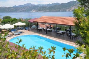 a resort with a swimming pool and a view of the water at Lacivert Boutique Hotel in Selimiye