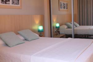 a bedroom with a large white bed with two lamps at Advise Hotels Reina in Vera