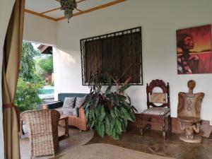 una sala de estar con sillas y una planta en Sunset Villa Eco Friendly House, en Kilifi