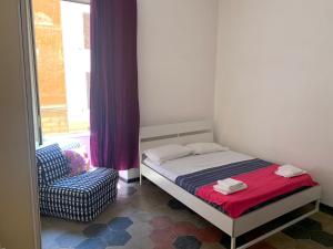 a small bedroom with a bed and a chair at Trasteverome45 in Rome