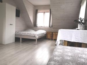 a bedroom with two beds and a window at ekoLOKUM - kameralnie, blisko centrum in Ostróda