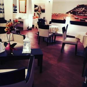 un ristorante con tavoli e sedie e una sala da pranzo di Bi Hotel a Porto Ercole