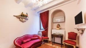 uma sala de estar com cadeiras vermelhas e uma televisão em Residenza La Salute em Veneza
