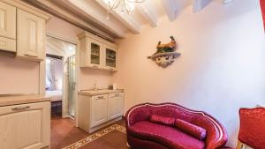 uma cozinha com uma cadeira vermelha e um lavatório em Residenza La Salute em Veneza