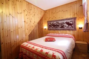 um quarto com uma cama numa parede de madeira em Lo Stambecco Holiday Apartment - Affitti Brevi Italia em Brusson