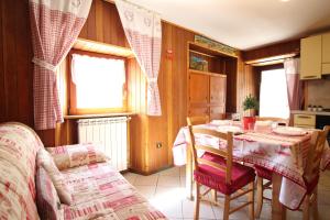 eine Küche mit einem Tisch, einem Tisch und Stühlen in der Unterkunft Lo Stambecco Holiday Apartment - Affitti Brevi Italia in Brusson