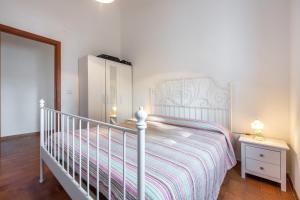 sypialnia z łóżkiem, komodą i łóżeczkiem dziecięcym w obiekcie Appartamento in Villa Erica w mieście Torre delle Stelle