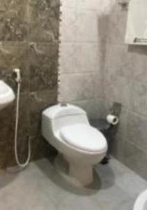 a bathroom with a white toilet and a sink at Ashbilia Suites in Al Khobar