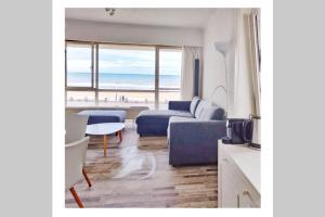 a living room with a blue couch and the beach at Royal Palace Seaview Suite in Ostend