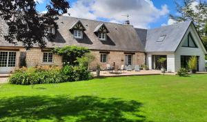 a large brick house with a patio and a yard at Les Hortensias-chambre chez l'habitant in Bretteville-du-Grand Caux