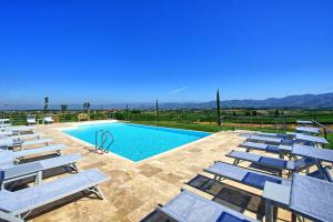 una piscina con sedie a sdraio e vista sulle montagne di Il Sole di Vino by PosarelliVillas a Vinci