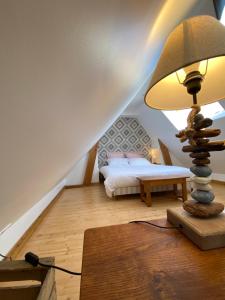 a bedroom with a bed and a lamp on a wooden floor at Les Apparts in Genneville