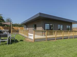 a small house with a deck and a table at Bluebell Wood in Great Driffield