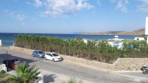 two cars parked in a parking lot next to the ocean at Vrahos Studios in Kionia