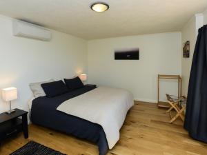 um quarto com uma cama grande com lençóis azuis e brancos em Marine Parade Magic - Napier Holiday Home em Napier