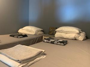 two beds with pillows and towels on them in a room at Charming house with panoramic sea view over Bråviken! in Norrköping