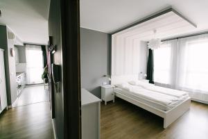 a bedroom with a white bed and white walls at Renttner Apartamenty in Warsaw