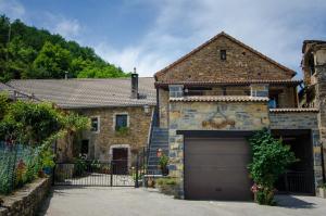 a stone house with a garage and a driveway at Borda Diego in Ligüerre de Ara