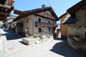 a building on a street with a courtyard at Lo Stambecco Holiday Apartment - Affitti Brevi Italia in Brusson