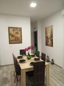 a dining room table with chairs and flowers on it at Alojamientos rurales La Barca del tío Vito in Peloche