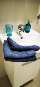 um balcão branco com uma toalha azul no lavatório em Apartment MINT em Senec
