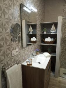 a bathroom with a sink and a mirror at Alojamientos rurales La Barca del tío Vito in Peloche