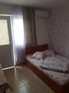 ein kleines Schlafzimmer mit einem Bett und einem Fenster in der Unterkunft Casa Flaviu Eforie Sud in Eforie Sud