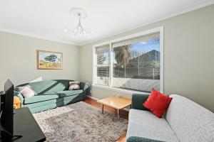 ein Wohnzimmer mit 2 Sofas und einem Fenster in der Unterkunft Coastal City Retreat - New Brighton Accommodation in Christchurch