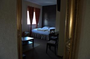 a mirror reflecting a bedroom with a bed and a window at Villa Bella Casa in Łomianki